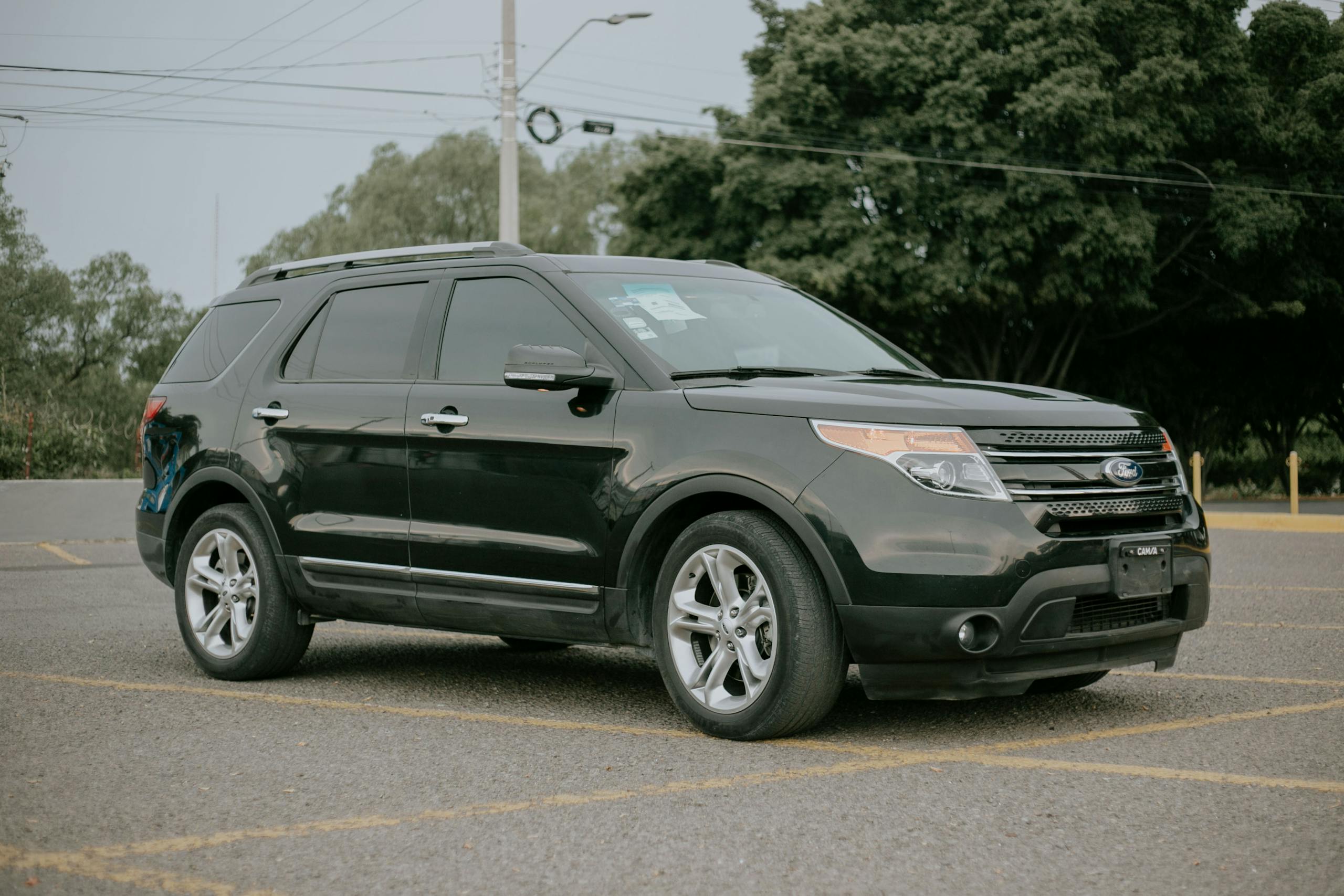 A black SUV parked outdoors in a spacious and empty parking area.